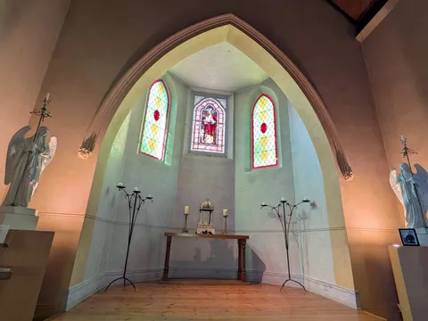 The convent's chapel, with a stained-glass window above a simple altar flanked by two angel statues.